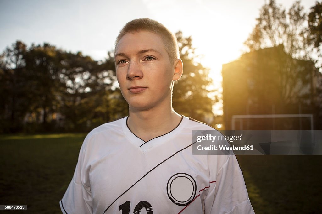 Confident teenager on soccer pitch
