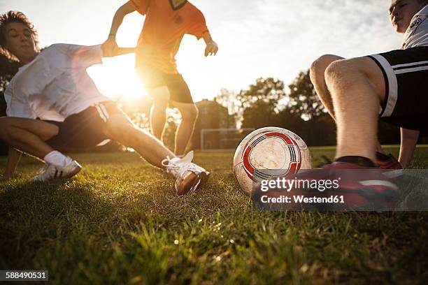 sliding tackle on soccer pitch - tackling fotografías e imágenes de stock