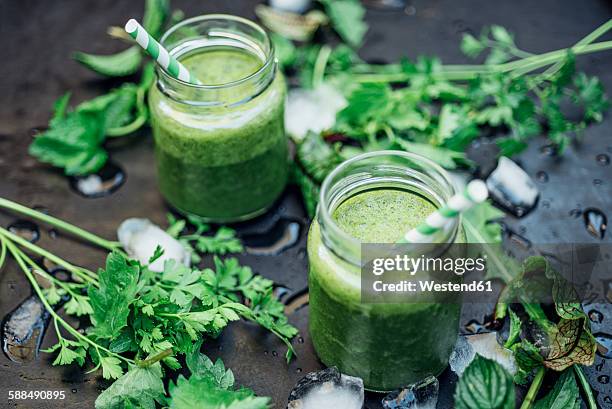 two glasses of wild herb smoothie with apple, banana and lime juice - sauerampfer stock-fotos und bilder