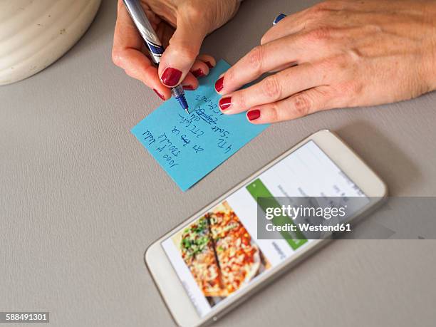 woman writing down recipe on a note - shopping list stock pictures, royalty-free photos & images