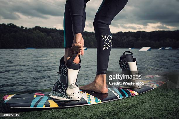 young wakeboarder preparing at lakeshore - lakeshore stockfoto's en -beelden