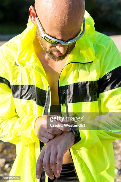 man in sports wear adjusting his smartwatch - best sunglasses for bald men fotografías e imágenes de stock