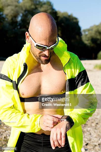 man in sports wear adjusting his smartwatch - best sunglasses for bald men fotografías e imágenes de stock