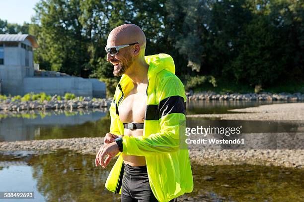 confident man in sports wear adjusting his smartwatch - best sunglasses for bald men stock pictures, royalty-free photos & images