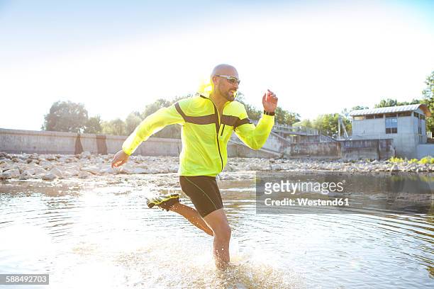 man in sports wear running in water - best sunglasses for bald men fotografías e imágenes de stock