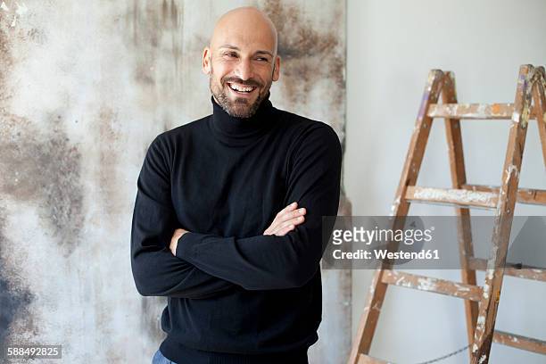 portrait of smiling man with crossed arms wearing black turtleneck - rollkragenpullover stock-fotos und bilder