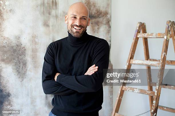 portrait of smiling man with crossed arms wearing black turtleneck - black turtleneck stock pictures, royalty-free photos & images