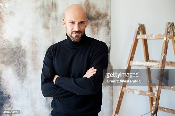 portrait of man with crossed arms wearing black turtleneck - arrogant stock-fotos und bilder