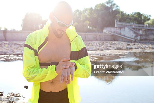 man in sports wear adjusting his smartwatch - best sunglasses for bald men fotografías e imágenes de stock
