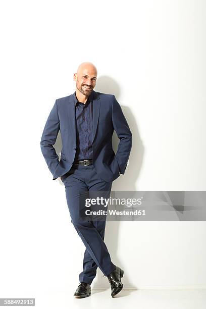 portrait of bald man with beard wearing blue suit in front of white background - bald man foto e immagini stock