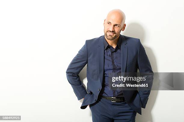 portrait of bald man with beard wearing blue suit in front of white background - male man portrait one person business confident background stockfoto's en -beelden