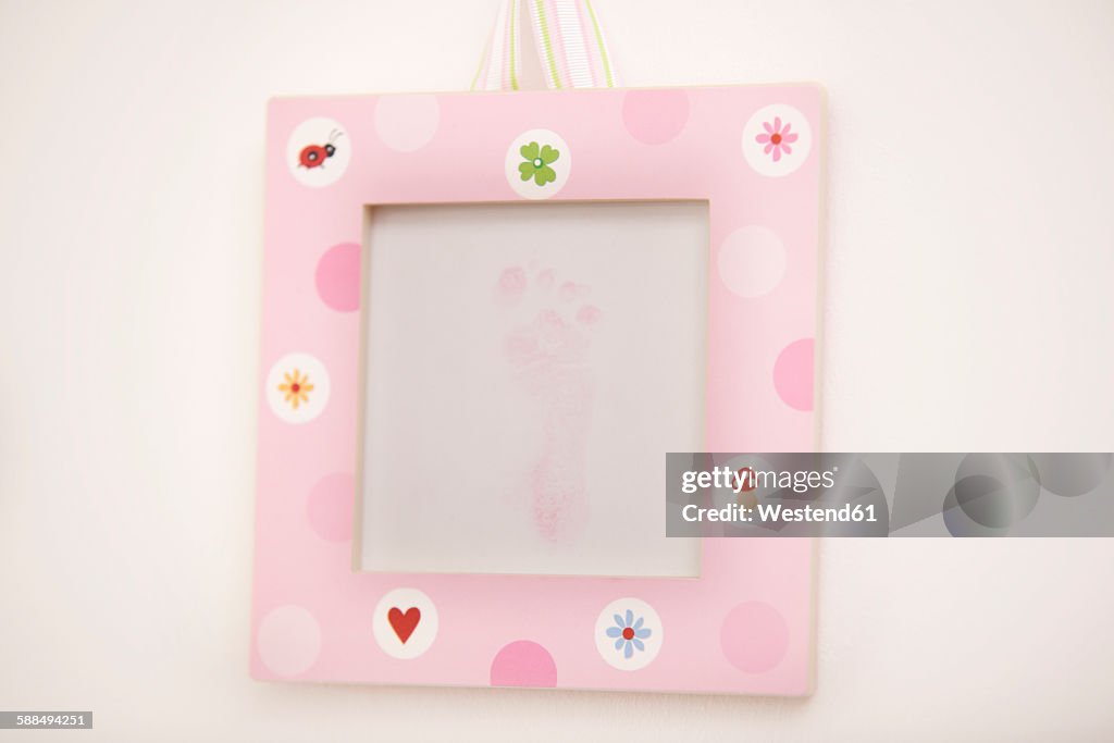 Pink picture frame with footprint of a newborn girl