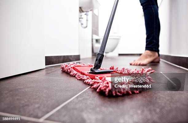 woman wiping the floor in bathroom - mop stock-fotos und bilder