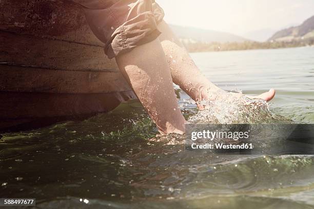 austria, tyrol, woman's feet splashing in water of walchsee - tirol deelstaat stockfoto's en -beelden