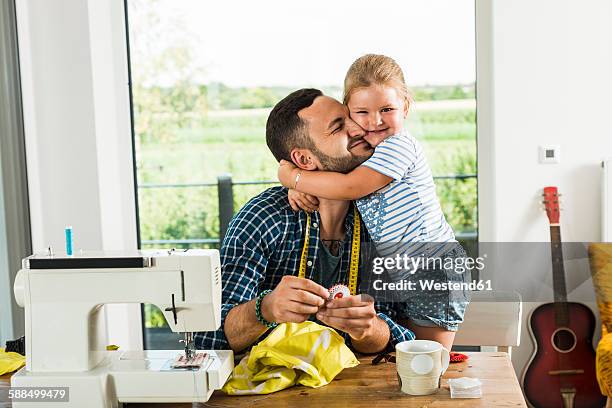 happy daughter cuddling father at home - nähen stock-fotos und bilder