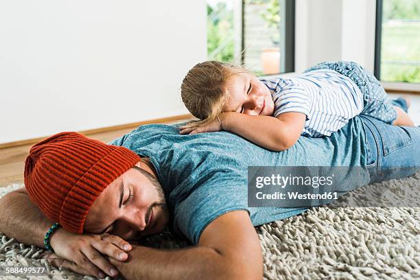 father-and-daughter-sleeping-on-rug-at-home.jpg