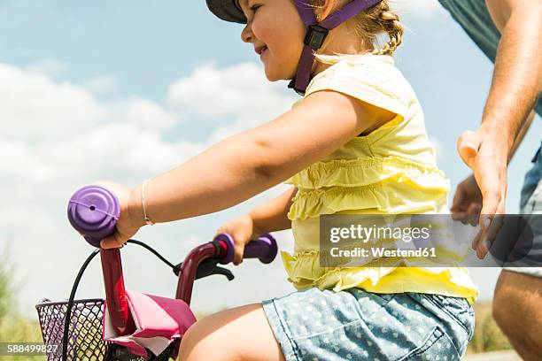 father accompanying daughter on bike - familie fietsen close up stockfoto's en -beelden
