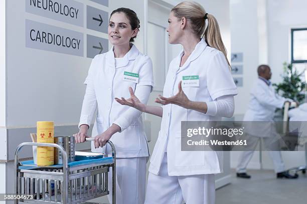 two nurses in hospital corridor talking - hospital cart stock pictures, royalty-free photos & images