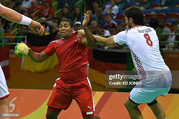 Denmark's centre back Mads Mensah Larsen vies with Croatia's right back Marko Kopljar during the men's preliminaries Group A handball match Denmark...