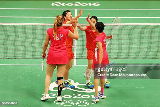 Ayaka Takahashi and Misaki Matsutomo of Japan high five each other after they compete against Ashwini Ponnappa and Jwala Gutta of India in the Womens...