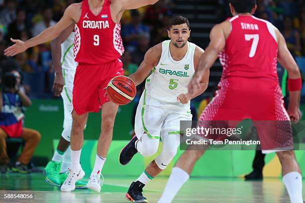 Raulzinho Neto of Brazil dribbles the ball against Krunoslav Simon of Croatia during the Men's Basketball - Preliminary Round Group B Brazil vs...