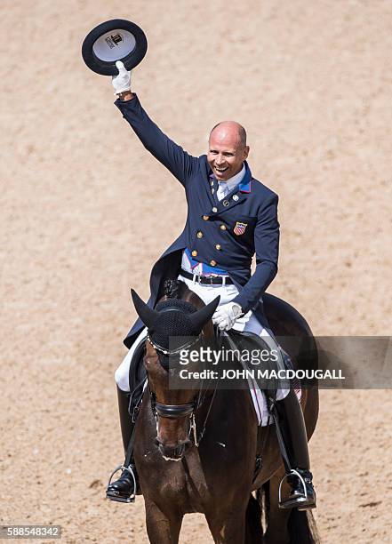 Steffen Peters on Legolas 92 celebrates after performing his routine during the Equestrian's Dressage Grand Prix event of the 2016 Rio Olympic Games...