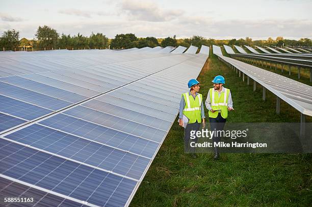 engineering surveyors talking on solar farm - environmental stewardship stock pictures, royalty-free photos & images