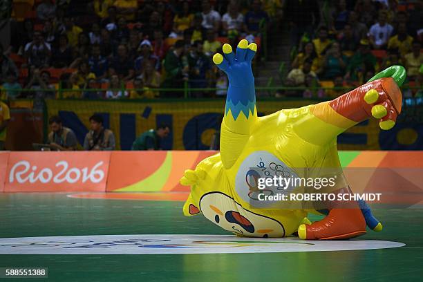Performer dressed as Rio 2016 Olympic Games mascot Vinicius dances during a break of the men's preliminaries Group B handball match Brazil vs Germany...