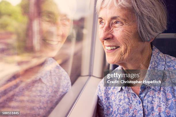 senior lady on a train - frau zug stock-fotos und bilder