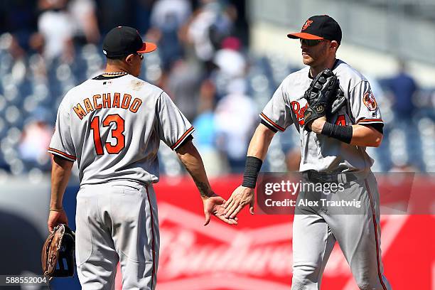 Manny Machado and Nolan Reimold of the Baltimore Orioles celebrate after defeating the New York Yankees 4-1 at Yankee Stadium on Thursday, July 21,...