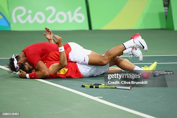 Marc Lopez of Spain and Rafael Nadal of Spain celebrate victory in their men's doubles semifinal against Daniel Nestor of Canada and Vasek Pospisil...