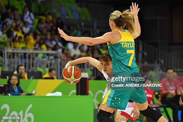 Japan's small forward Mika Kurihara works around Australia's forward Penny Taylor during a Women's round Group A basketball match between Japan and...