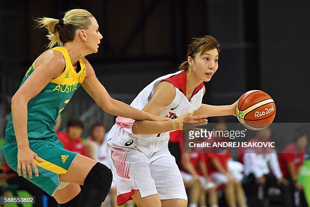 Japan's small forward Mika Kurihara works around Australia's forward Penny Taylor during a Women's round Group A basketball match between Japan and...