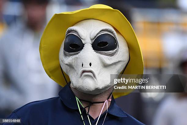 Spectator wearing an alien mask attends the women's singles quarter-final tennis match at the Olympic Tennis Centre of the Rio 2016 Olympic Games in...