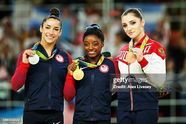 Silver medalist Alexandra Raisman of the United States, gold medalist Simone Biles of the United States and bronze medalist Aliya Mustafina of Russia...