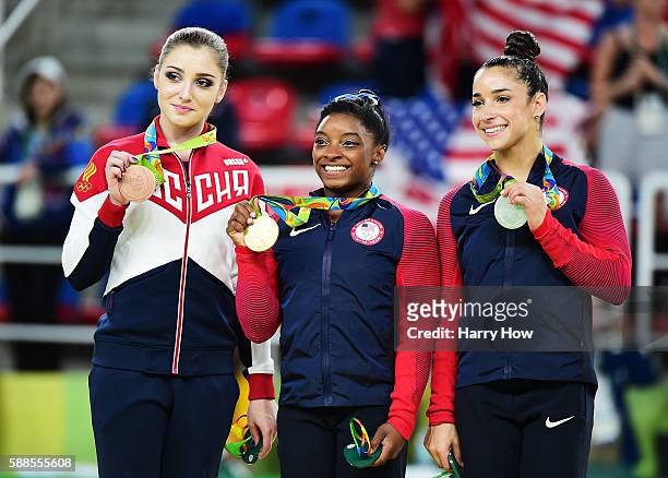 Bronze medalist Aliya Mustafina of Russia, gold medalist Simone Biles of the United States and silver medalist Alexandra Raisman of the United States...