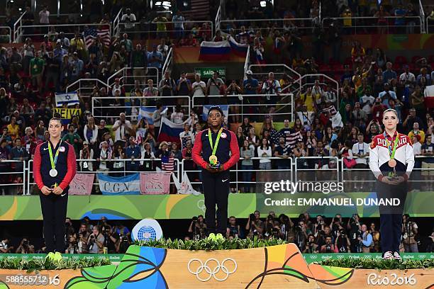 Russia's Aliya Mustafina, US gymnast Simone Biles and US gymnast Alexandra Raisman celebrate on the podium of the women's individual all-around final...