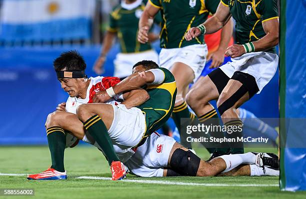 Rio , Brazil - 11 August 2016; Yusaku Kuwazuru of Japan scores a try despite the tackle of Juan de Jongh of South Africa during the Men's Rugby...