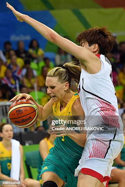 Australia's forward Penny Taylor works around Japan's power forward Ramu Tokashiki during a Women's round Group A basketball match between Japan and...