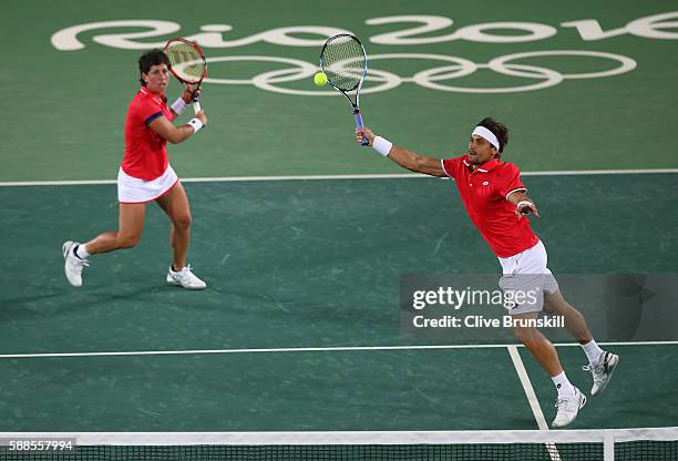 David Ferrer of Spain and Carla Suarez Navarro of Spain in action during the mixed doubles first round match against Andy Murray of Great Britain and...