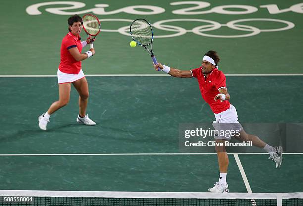 David Ferrer of Spain and Carla Suarez Navarro of Spain in action during the mixed doubles first round match against Andy Murray of Great Britain and...