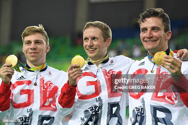 Gold medalists Britain's Philip Hindes, Jason Kenny and Callum Skinner pose on the podium after winning the men's Team Sprint track cycling finals at...