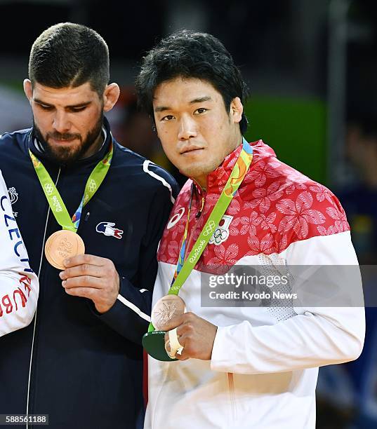 Japan's Ryunosuke Haga and France's Cyrille Maret attend a medal ceremony after both won bronze medals in the men's judo 100-kilogram category at the...