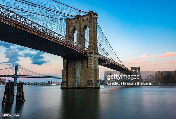 brooklyn bridge during sunset - puente de brooklyn fotografías e imágenes de stock