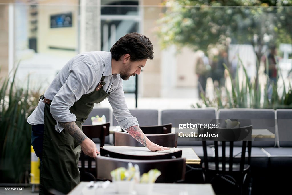 Waiter cleaning tables at a restaurant