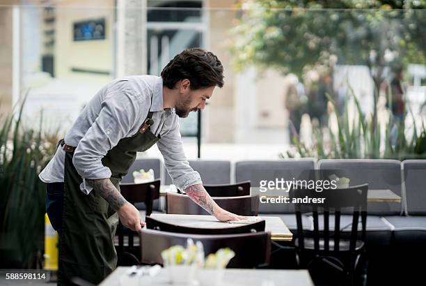 waiter cleaning tables at a restaurant - restaurant cleaning stock pictures, royalty-free photos & images