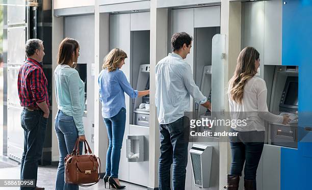 people in a line at an atm - bank stockfoto's en -beelden