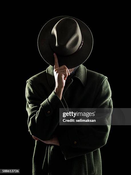 porträt des mannes versteckt sein gesicht mit fedora hut - secret agent stock-fotos und bilder