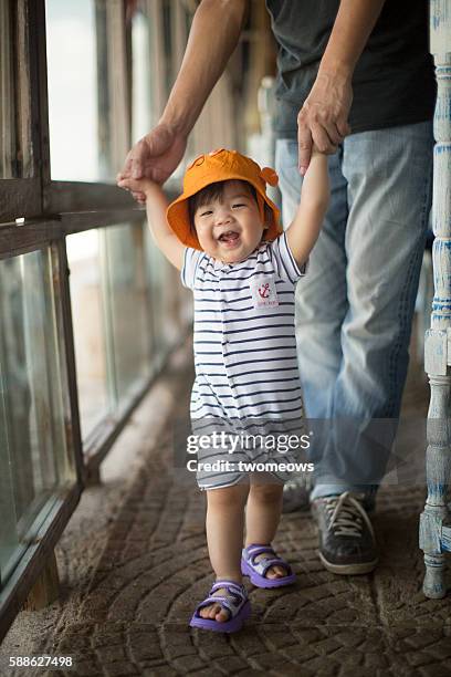 asian chinese toddler learn to walk. - super mom stock-fotos und bilder