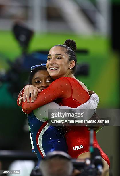 Simone Biles of the United States waits for the score after competing on the floor with Alexandra Raisman during the Women's Individual All Around...